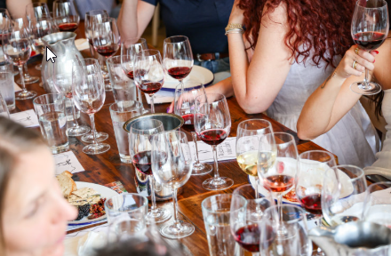 Kolleger til firmaevent med vinsmagning – vinglas og mad på bordet