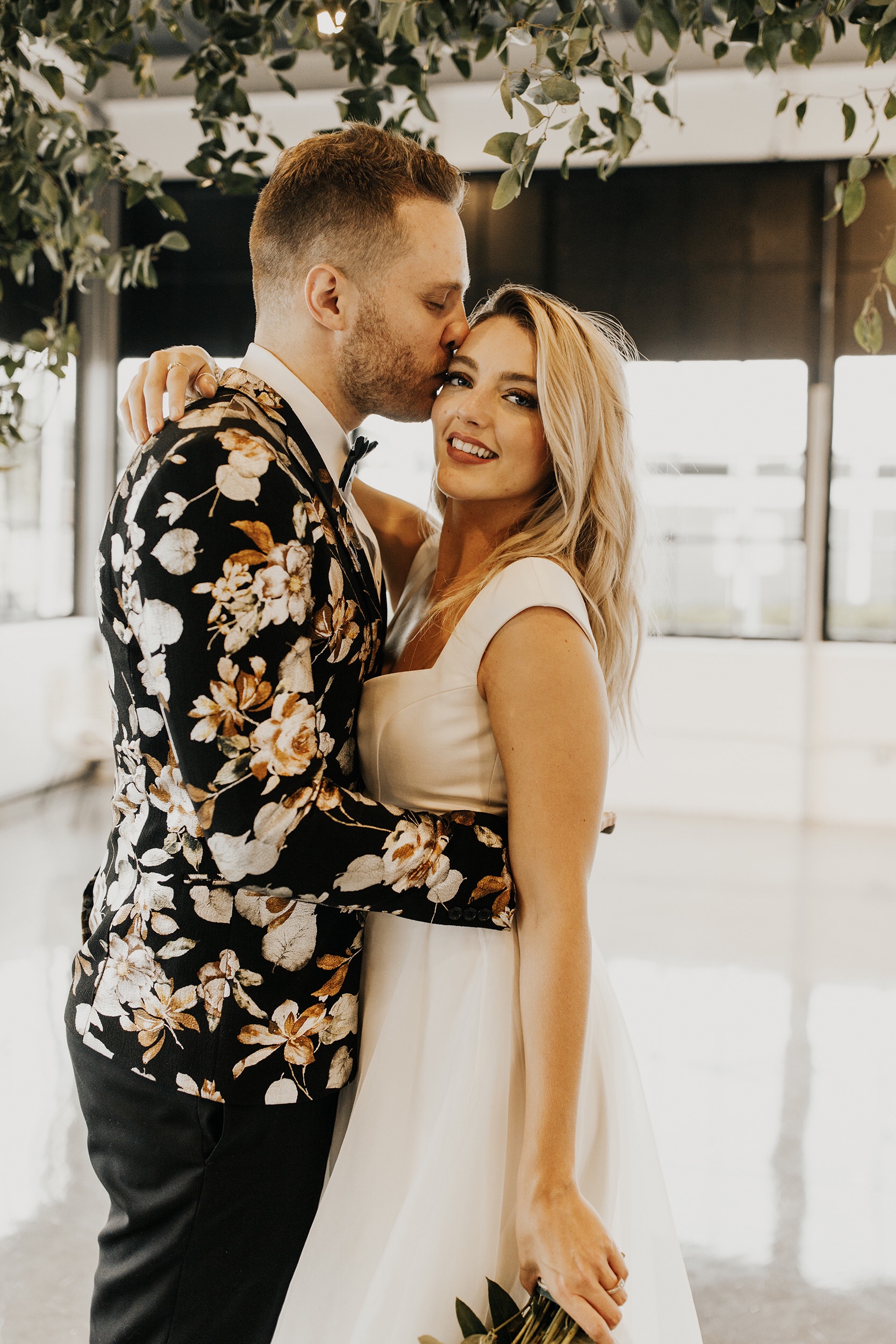 bohemian-styled-couple-kissing-in-kansas-city-venue-designed-by-wildly-yours-weddings-and-elopements-with-florals.jpeg