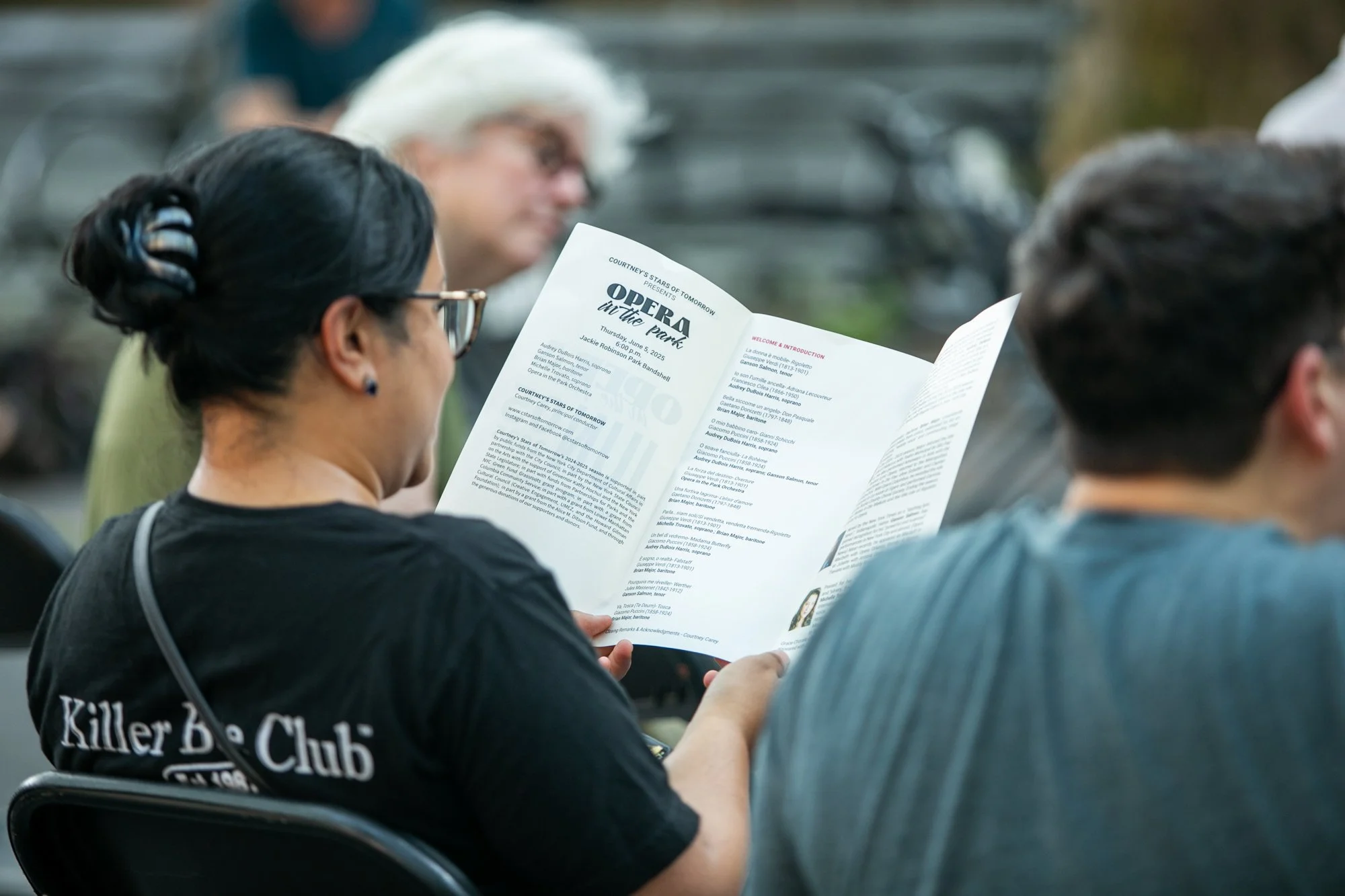 Audience members following the program at Opera in the Park.
