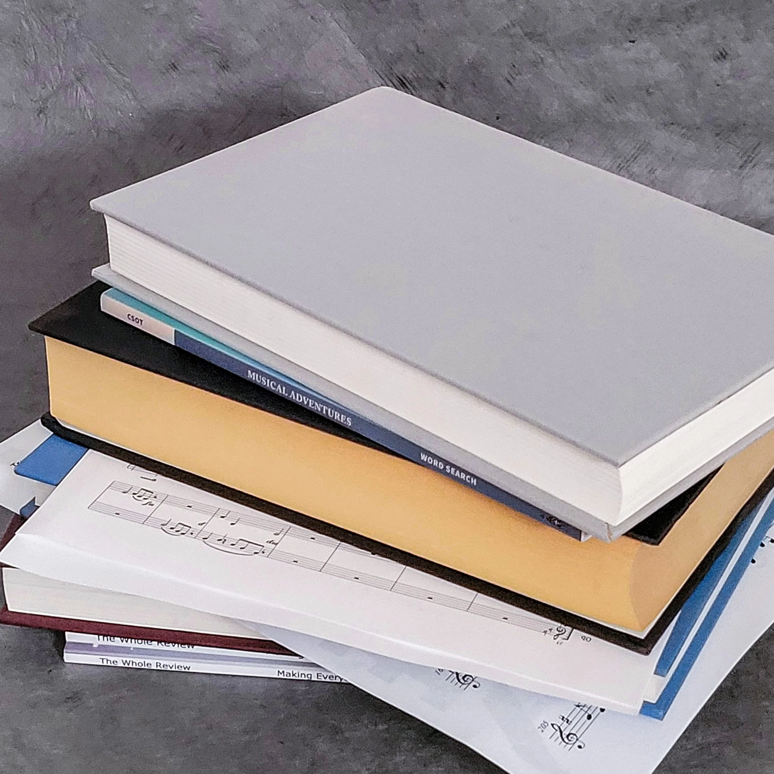 Stack of books and sheet music representing CSOT Publishing