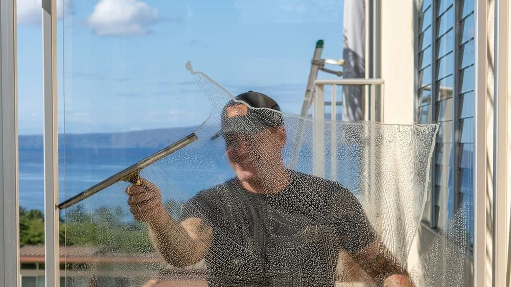 Squeegeeing a glass lanai railing in Wailea, Maui