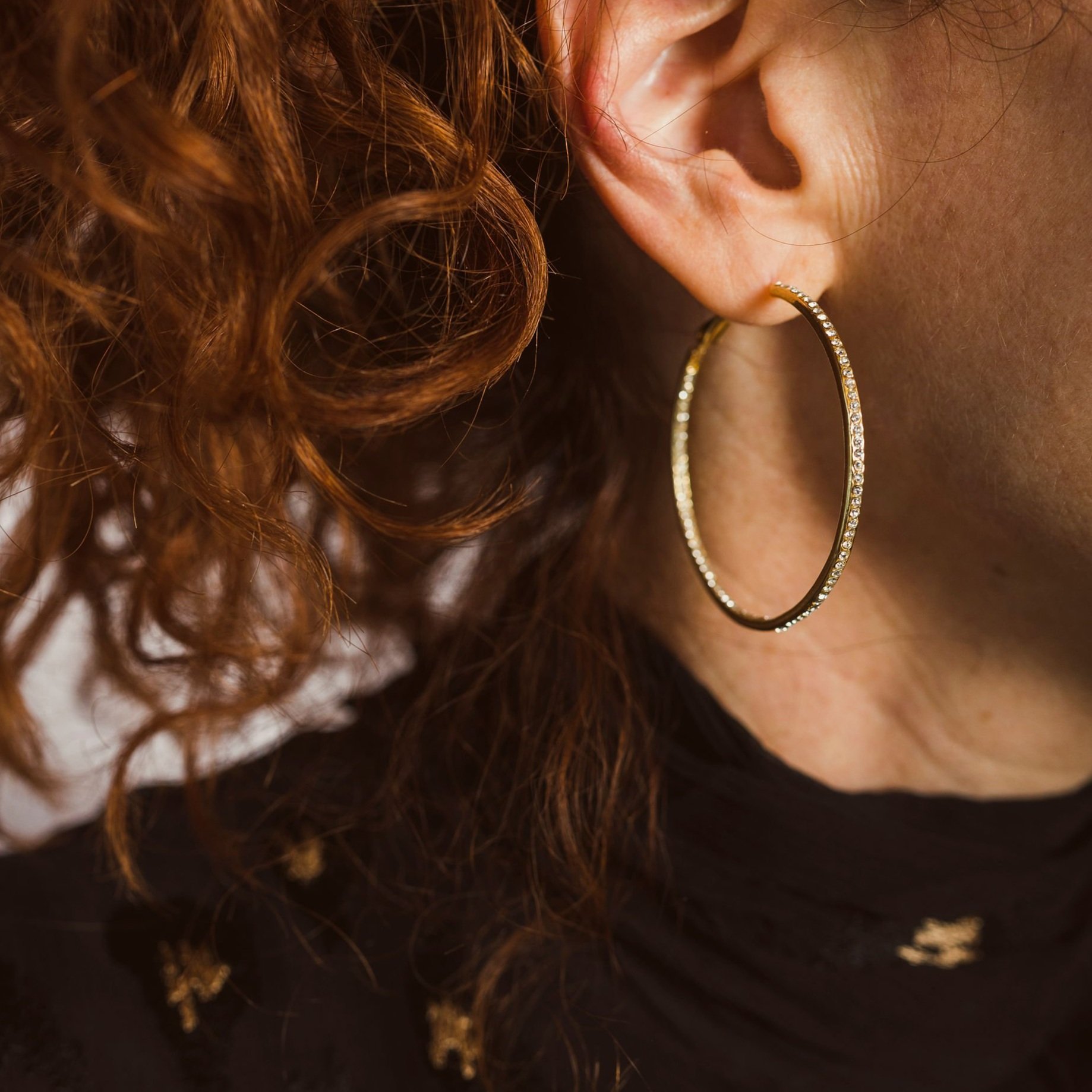 Diamond encrusted gold hoop earrings.