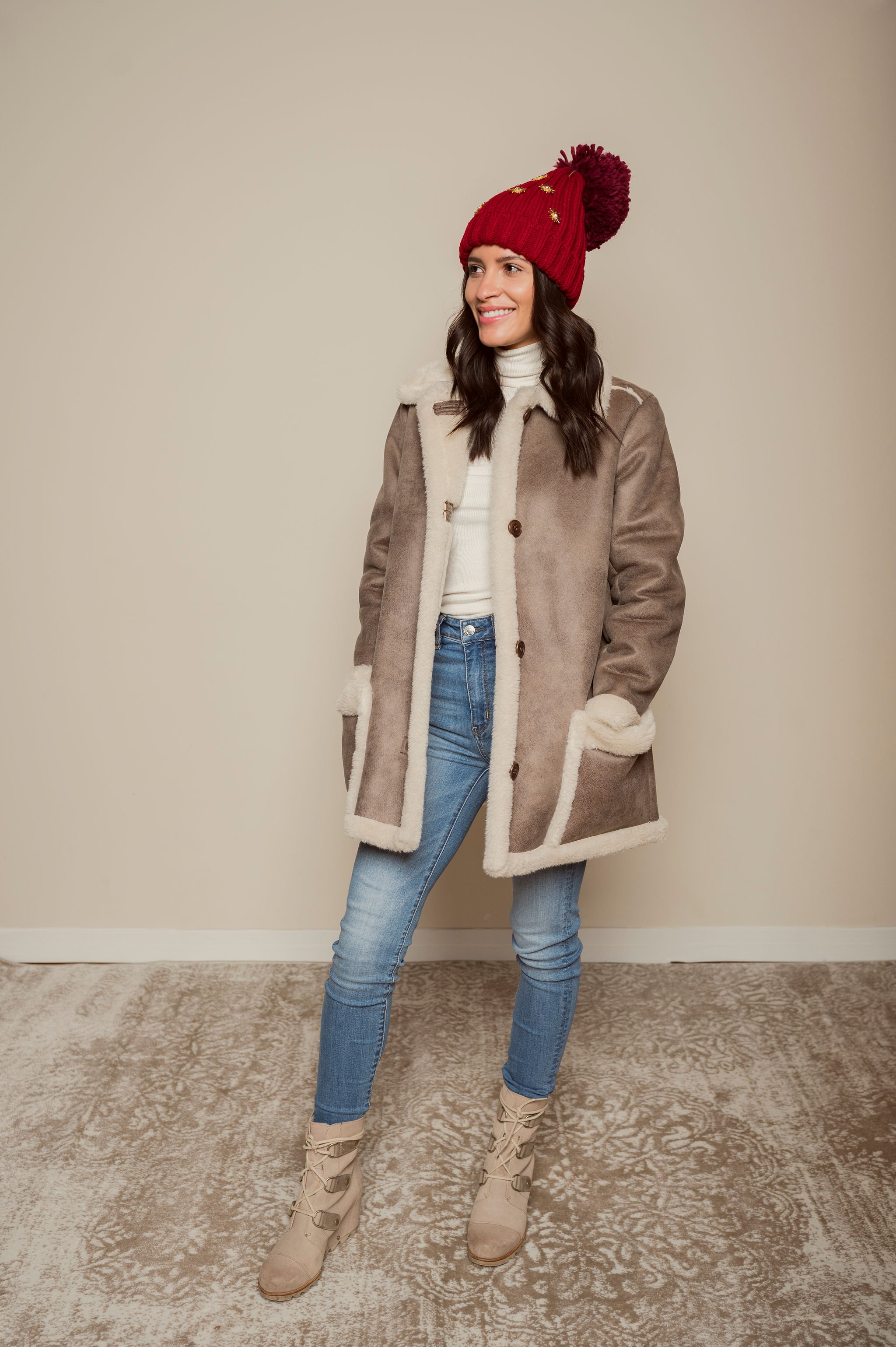  Whitney in white turtleneck dress down with denim and winterized with a pom pom and sequin hat. 