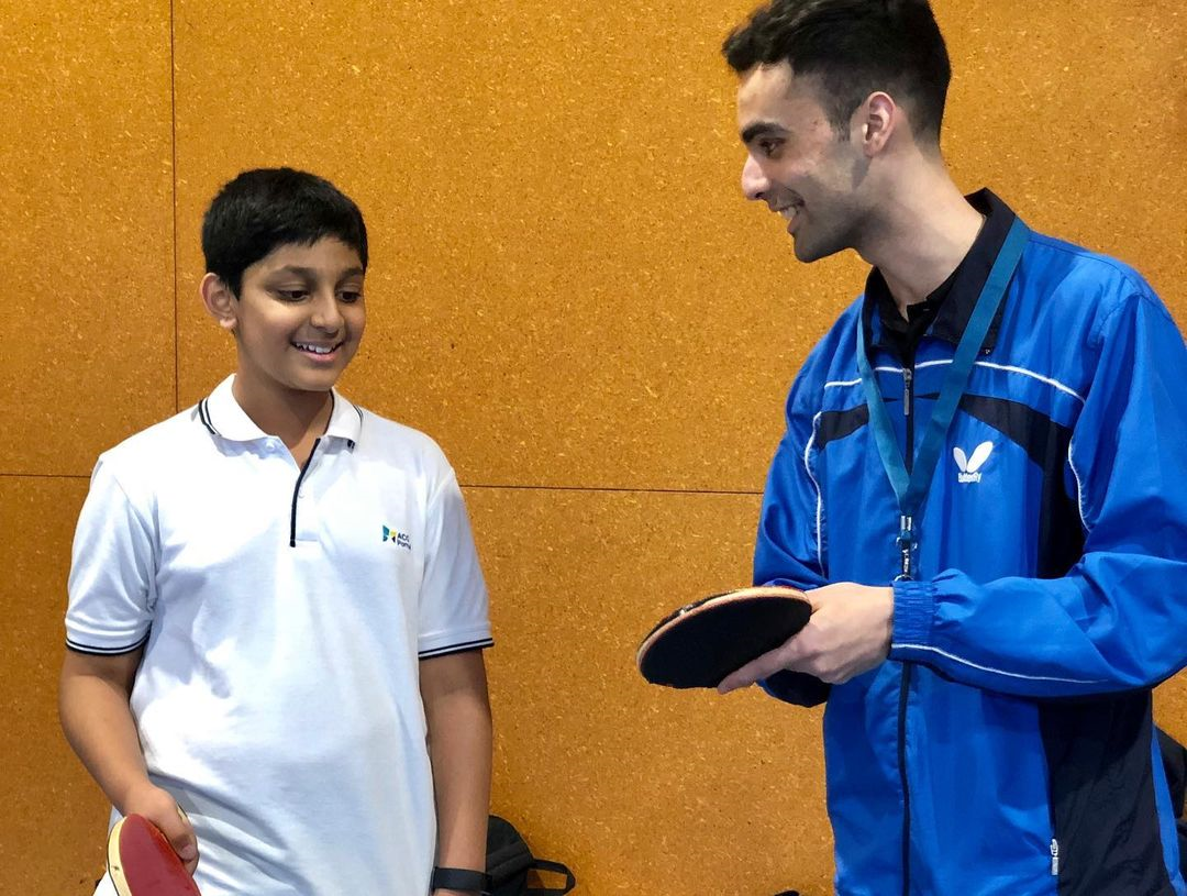 A photo of Dinyar Irani teaching an ACG Parnell student how to correctly hold a Table Tennis bat