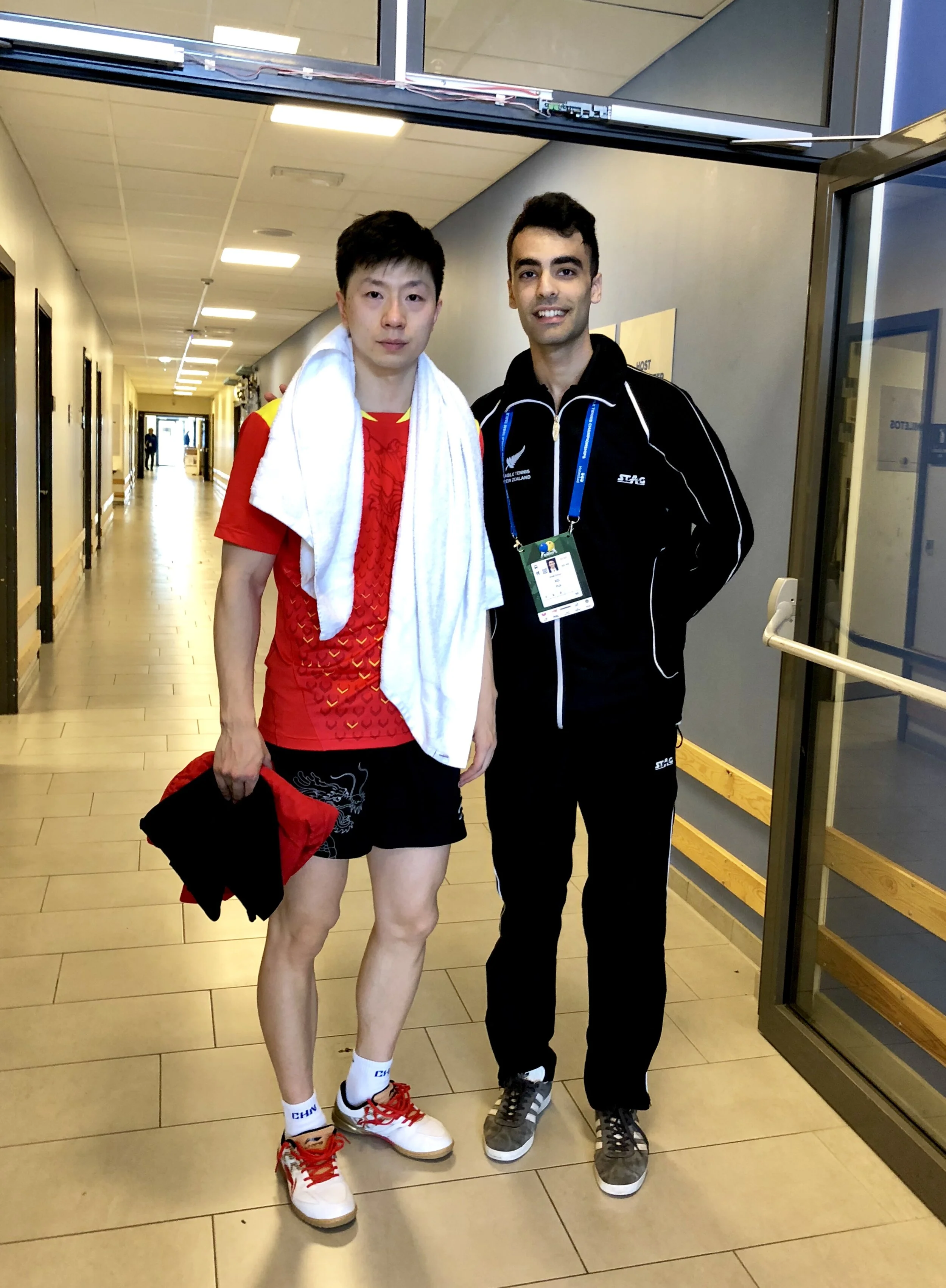 A photo of Dinyar Irani (NZL) and Ma Long (CHN)