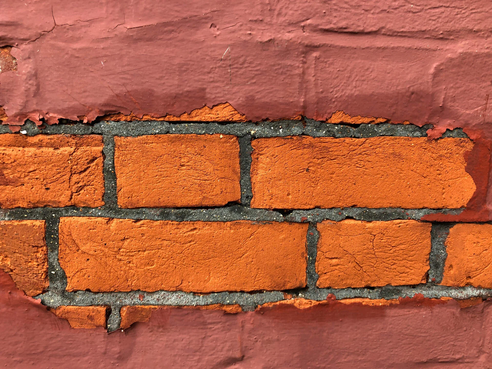 Paint removal from red brickwork revealing the original brick surface