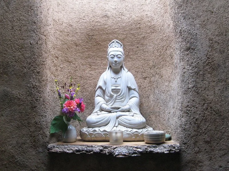 Buddhist statue of compassion with flowers
