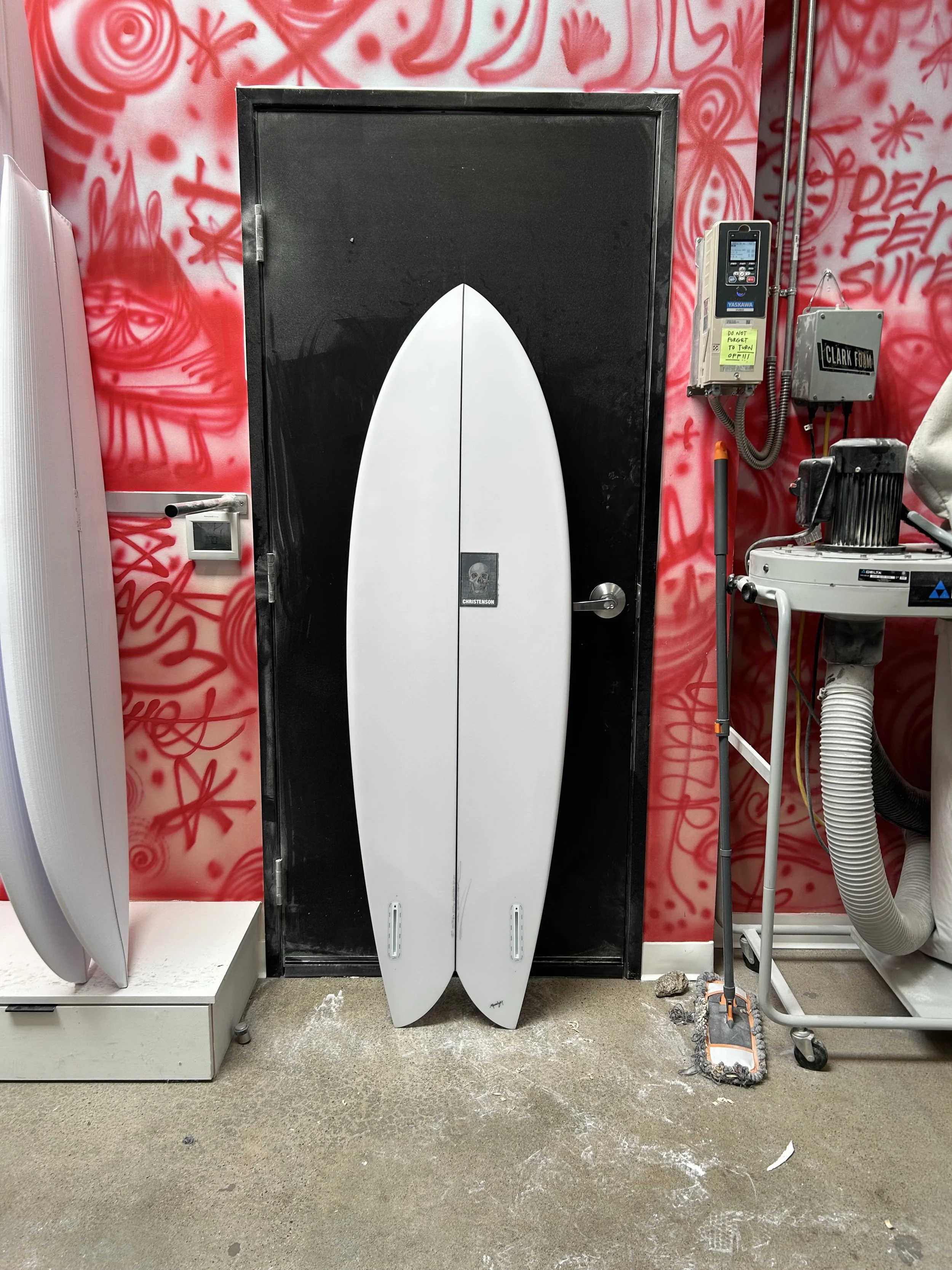 fish surfboard against black door