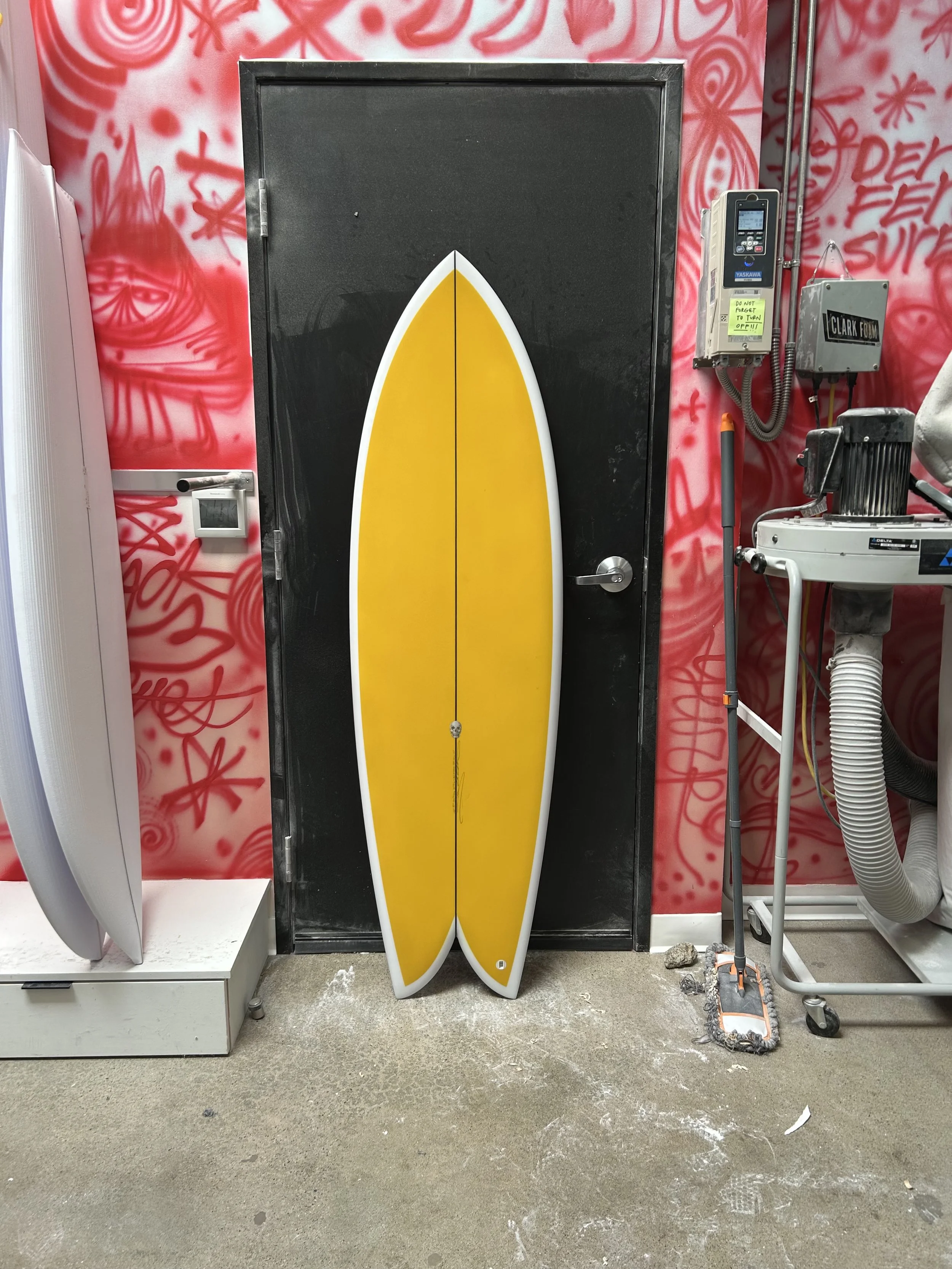 fish surfboard against black door