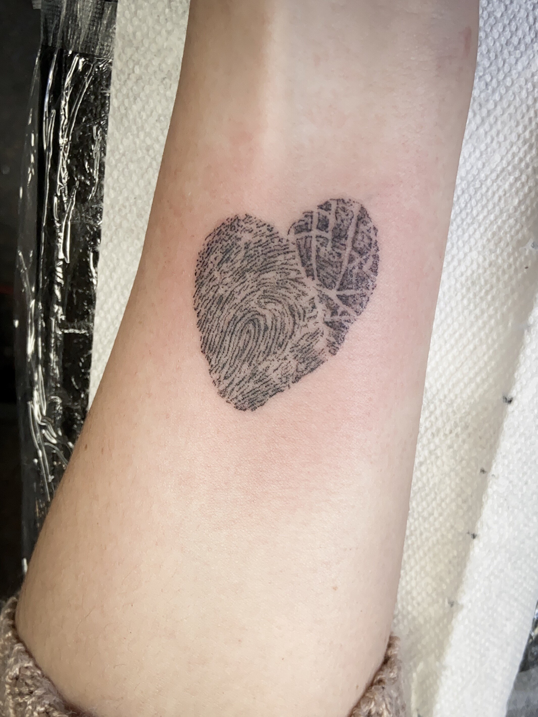  A detailed black and grey heart tattoo that is filled with fingerprint lines 