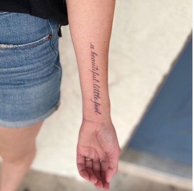  great gatsby quote “a beautiful little fool” tattooed on a persons forearm 