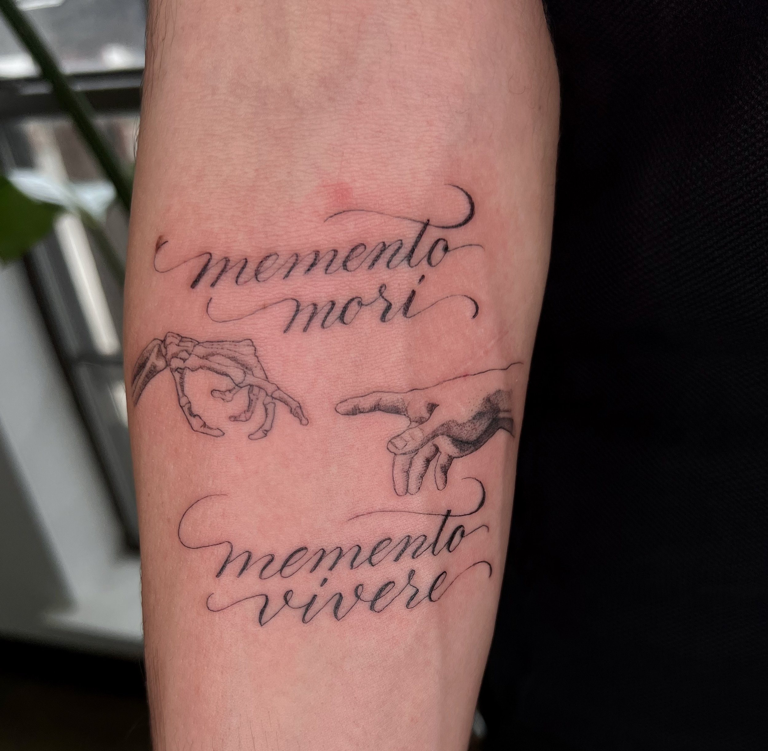  tattoo of hand drawn script with the words memento mori memento vivere, and a play on the creation painting  
