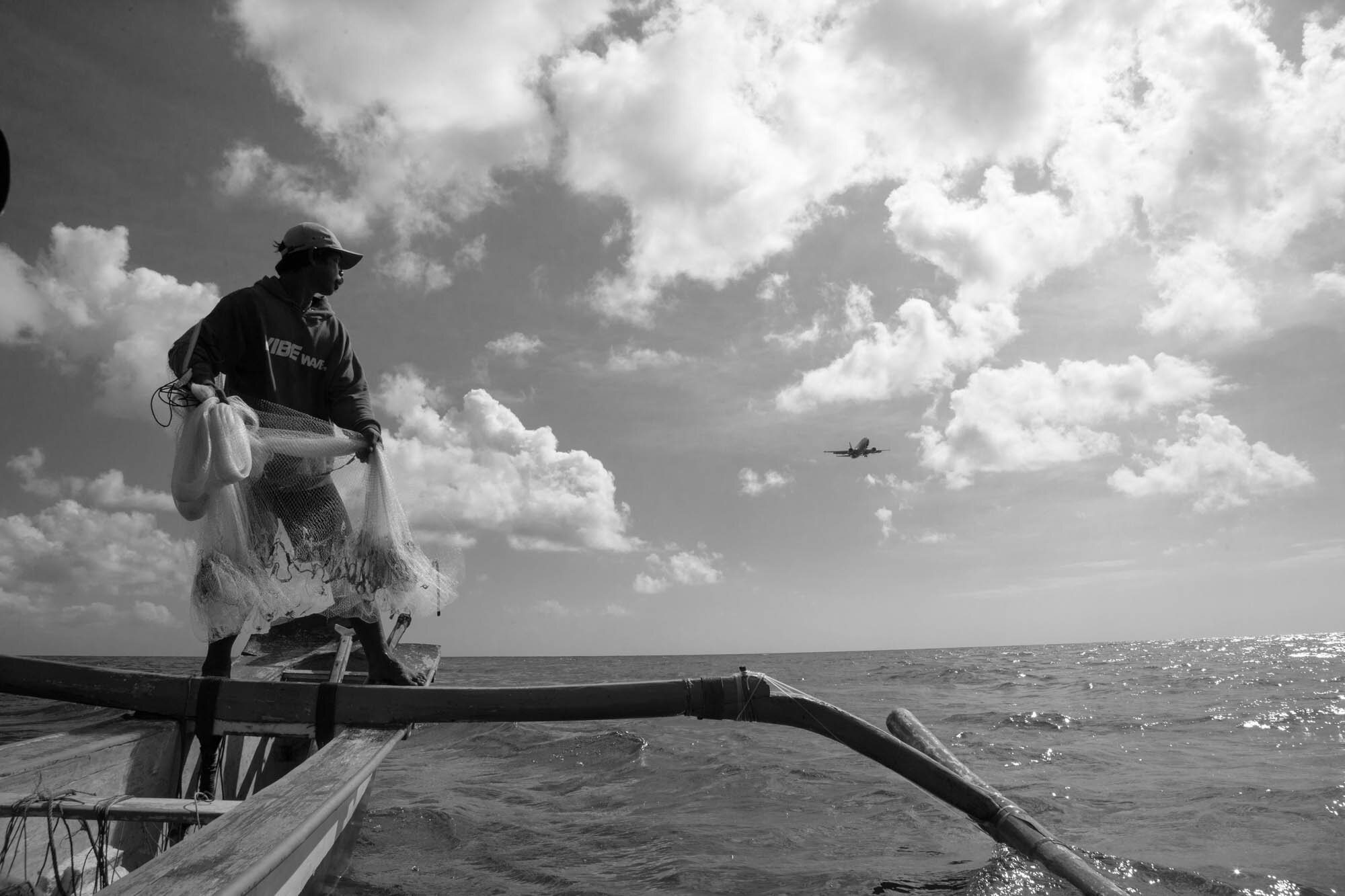  Jimbaran, Bali  Fisherman sights an incoming plan.    part of Tirta Bali book   