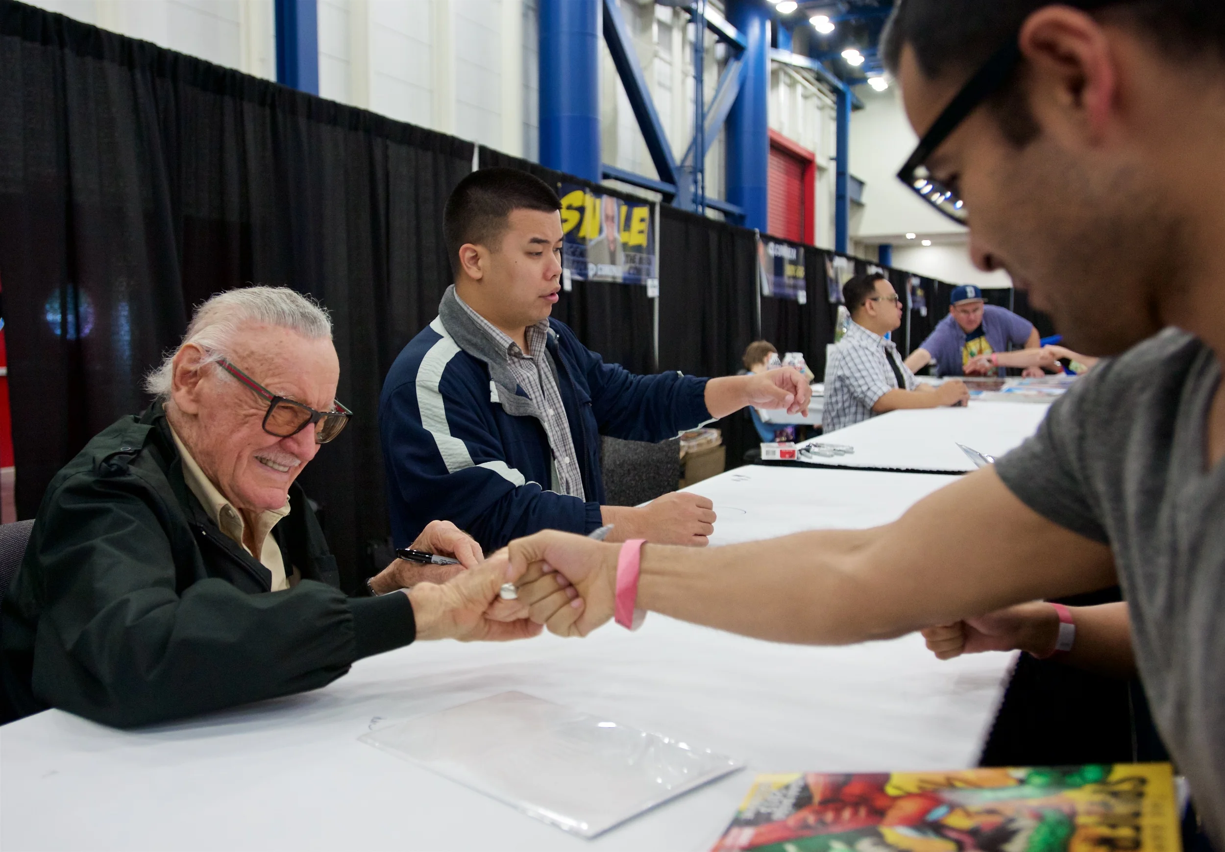 Stan "The Man" Lee fist bumps a fan at Comicpalooza