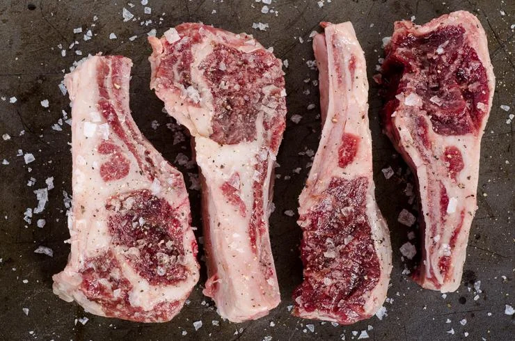 First we will get our onions and garlic sautéed until golden, then coat the rib chops in salt and pepper.