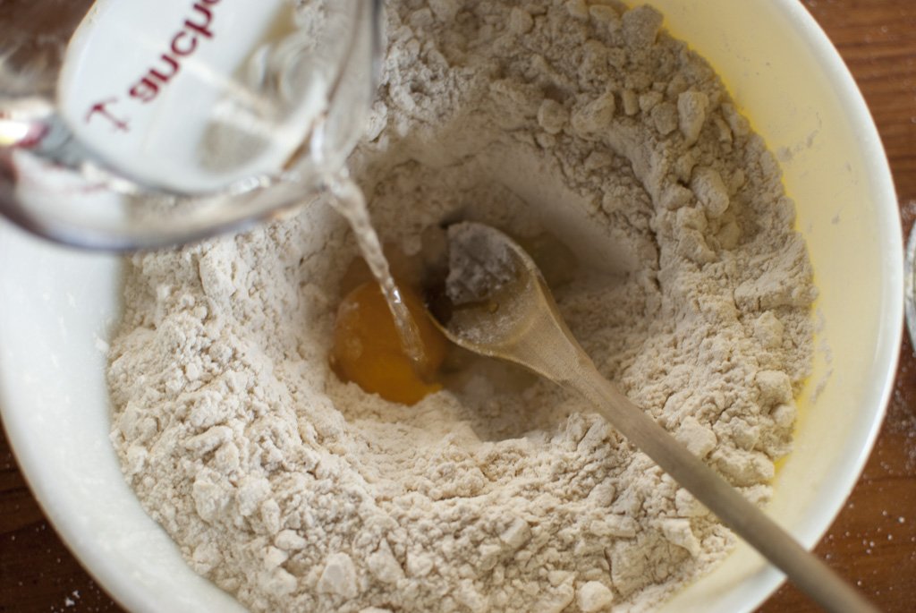 After cutting your butter into your flour mixture, create a well, add egg yolk and 1/2 cup water. Work in flour and add water as needed.