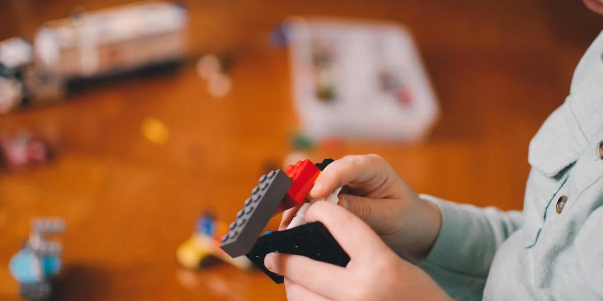 Child developing fine motor skills by stacking blocks and using both hands during play