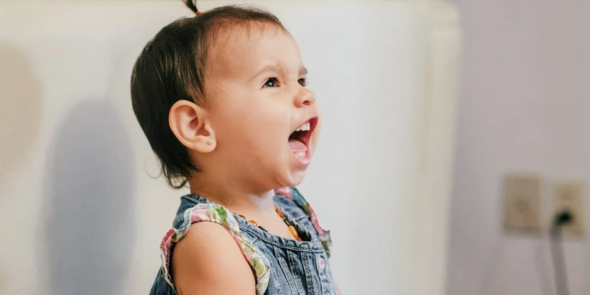 Parent encouraging baby speech and communication development through early language milestones