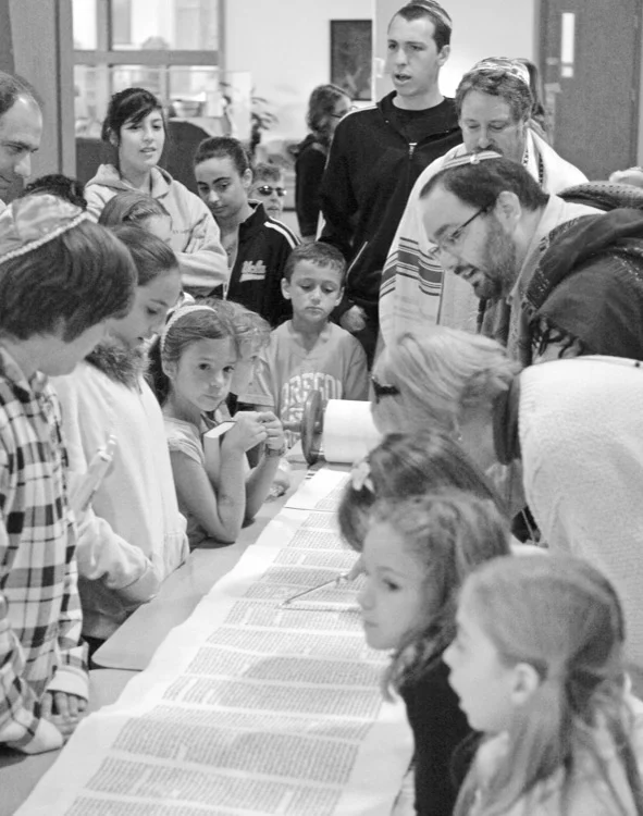 Rabbi James Green gathered with families around the Torah scroll on Simchat Torah