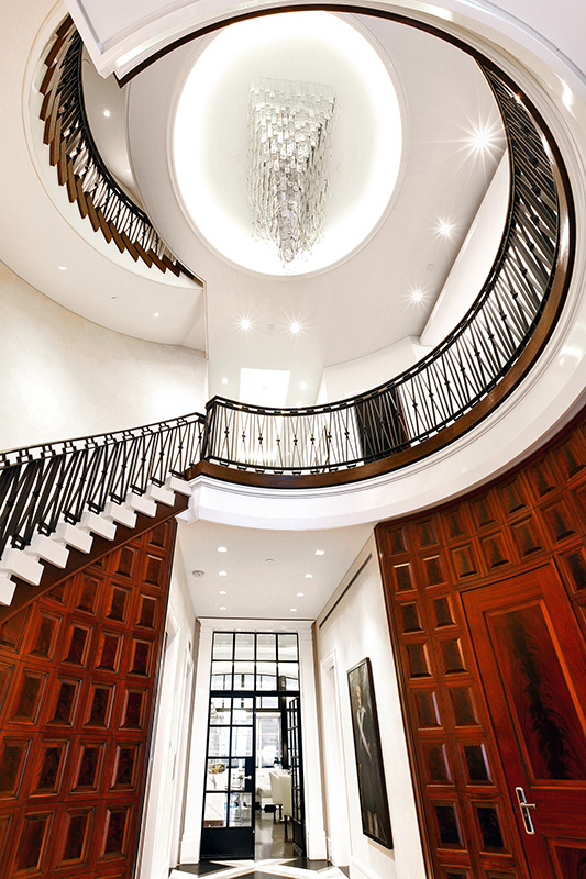 View of grand staircase and kitchen from foyer