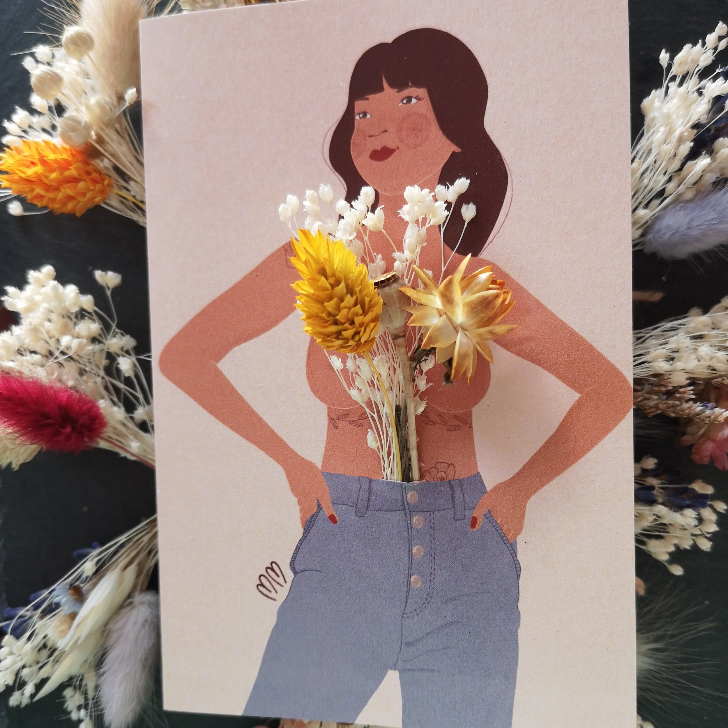 Une illustration d'une femme avec ses mains sur ses hanches. Des fleurs séchées sont placées devant sa poitrine, donnant un aspect artistique et créatif à l'image.
