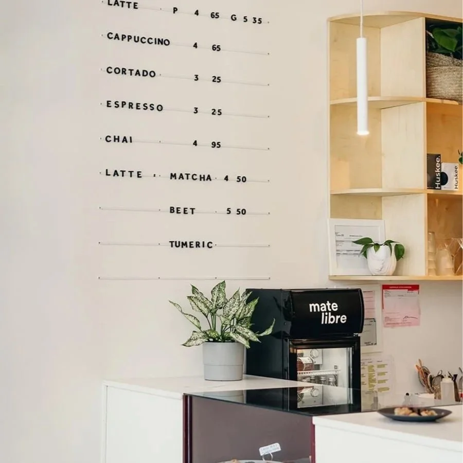 Carte du menu de boissons dans un café, affichant des cafés comme latte, cappuccino, espresso, chai, et des boissons comme matcha, beet, turmeric, avec leurs prix.