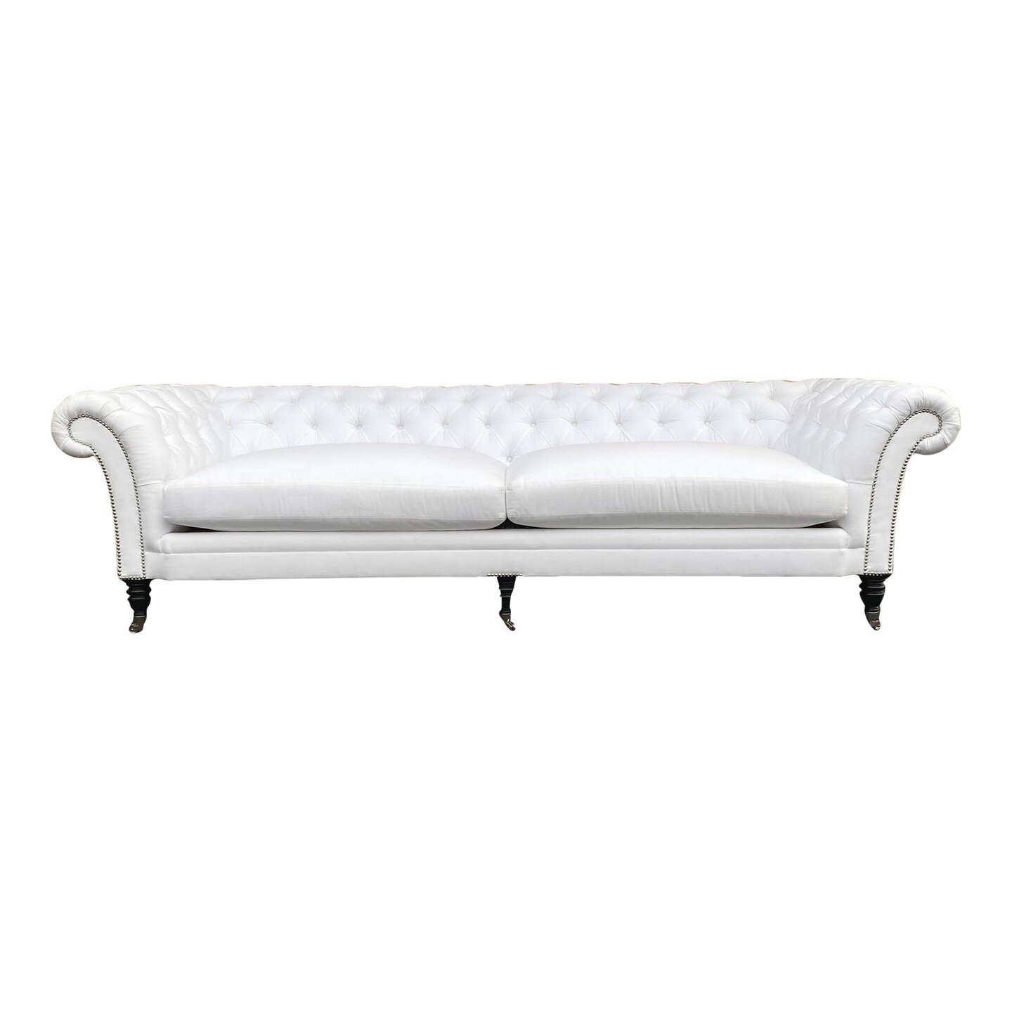 Brook Street Chesterfield Sofa in the Manner of Ralph Lauren

 Brook Street Sofa in the Manner of Ralph Lauren in a white fabric with English-style silver nailhead detail on arms and above legs. The sofa sits on carved legs with silver casters. The s