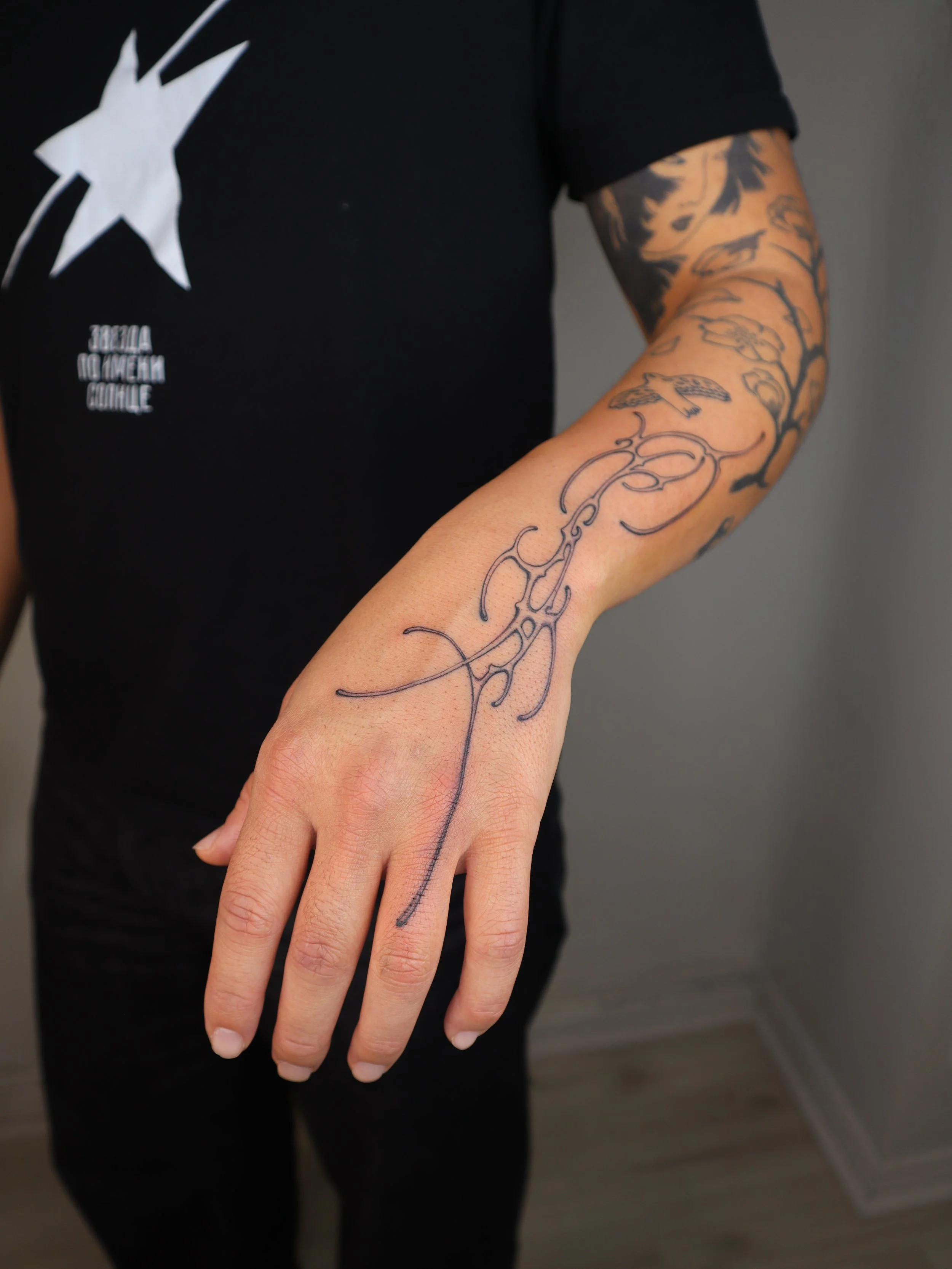 Custom neo-tribal hand tattoo designed by Helsinki tattoo artist Sister Serpent.