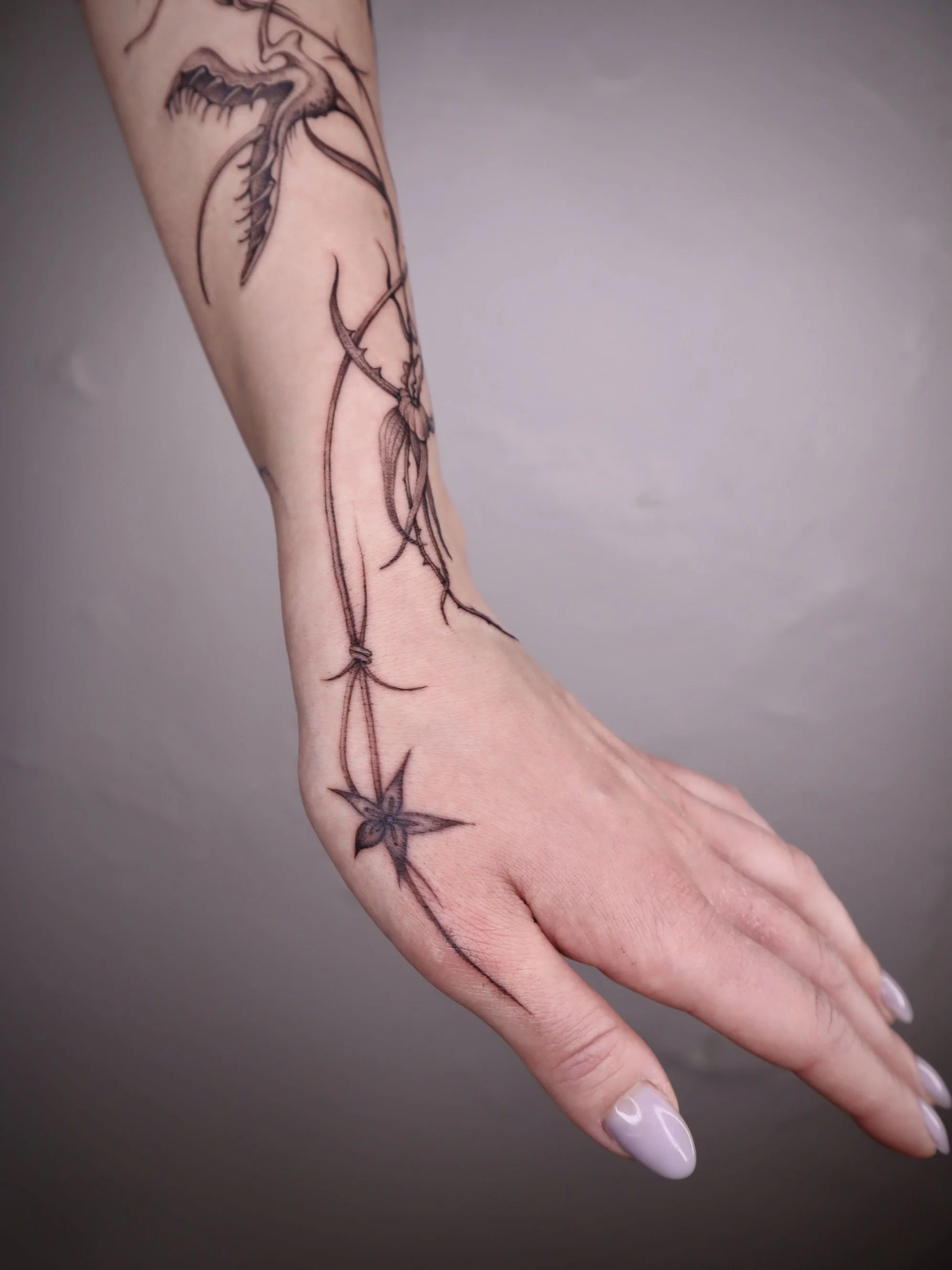 Floral fine line hand tattoo Helsinki