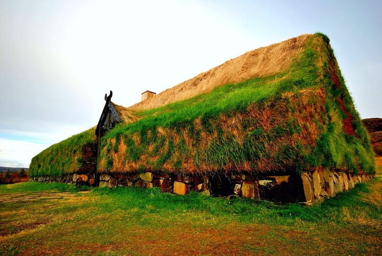 A reconstruction of a Viking longhouse made of wood, stone and turf. The simple layout features a common area complete with hearth and a single partition separating the sleeping quarters. Photo by 'Thomas Ormston' via Wikimedia Creative Commons