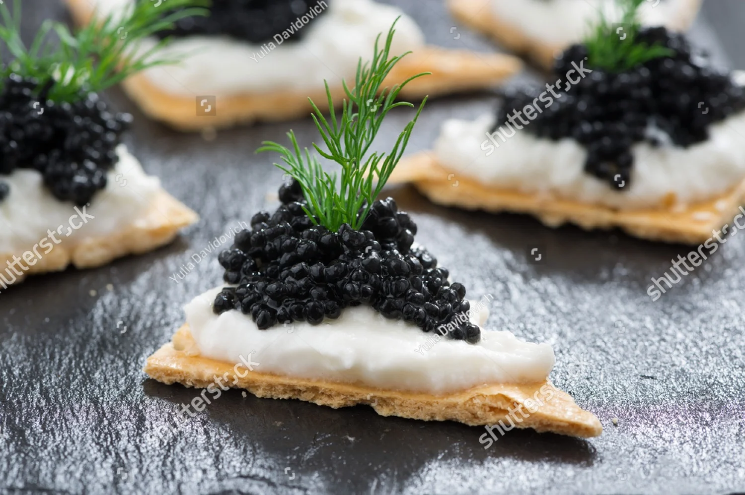 stock-photo-crackers-with-cream-cheese-and-black-caviar-horizontal-211444606.jpg
