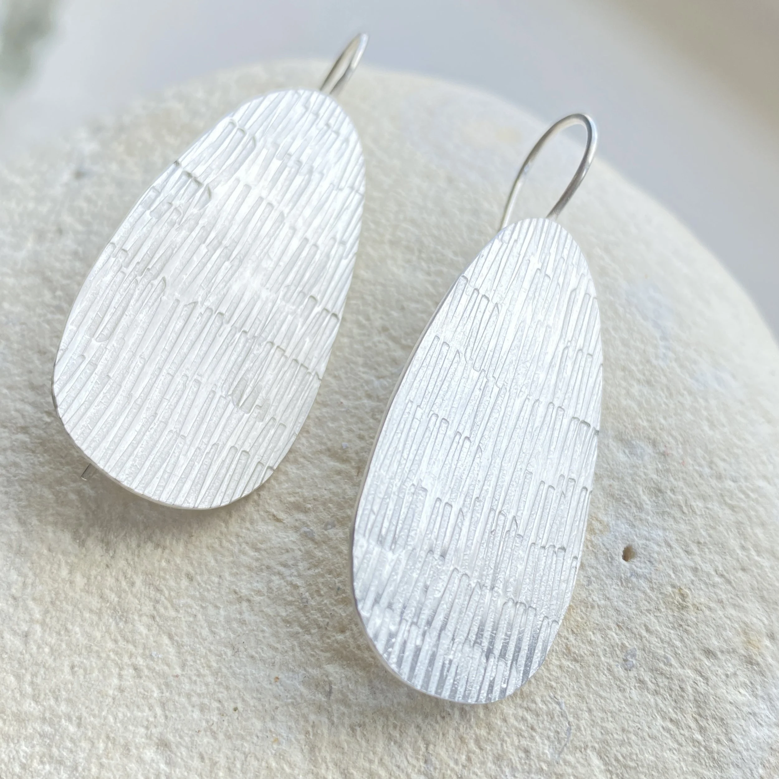 textured hand stamped statement silver earrings long pear shape