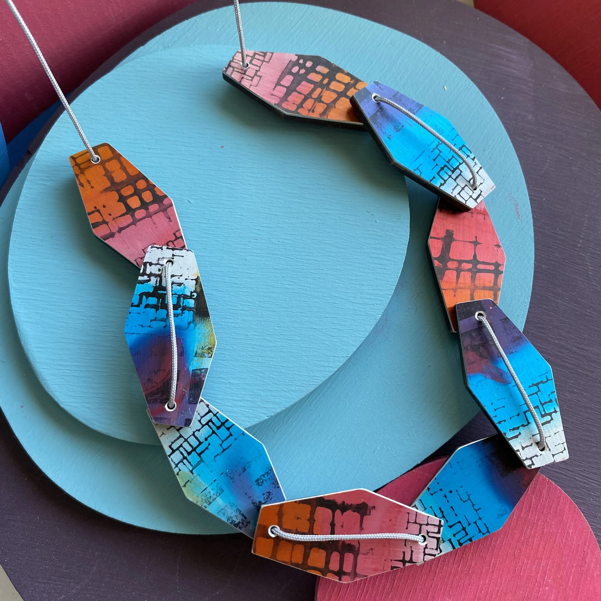 Blue/pink hexagonal 9 piece aluminium & walnut necklace.