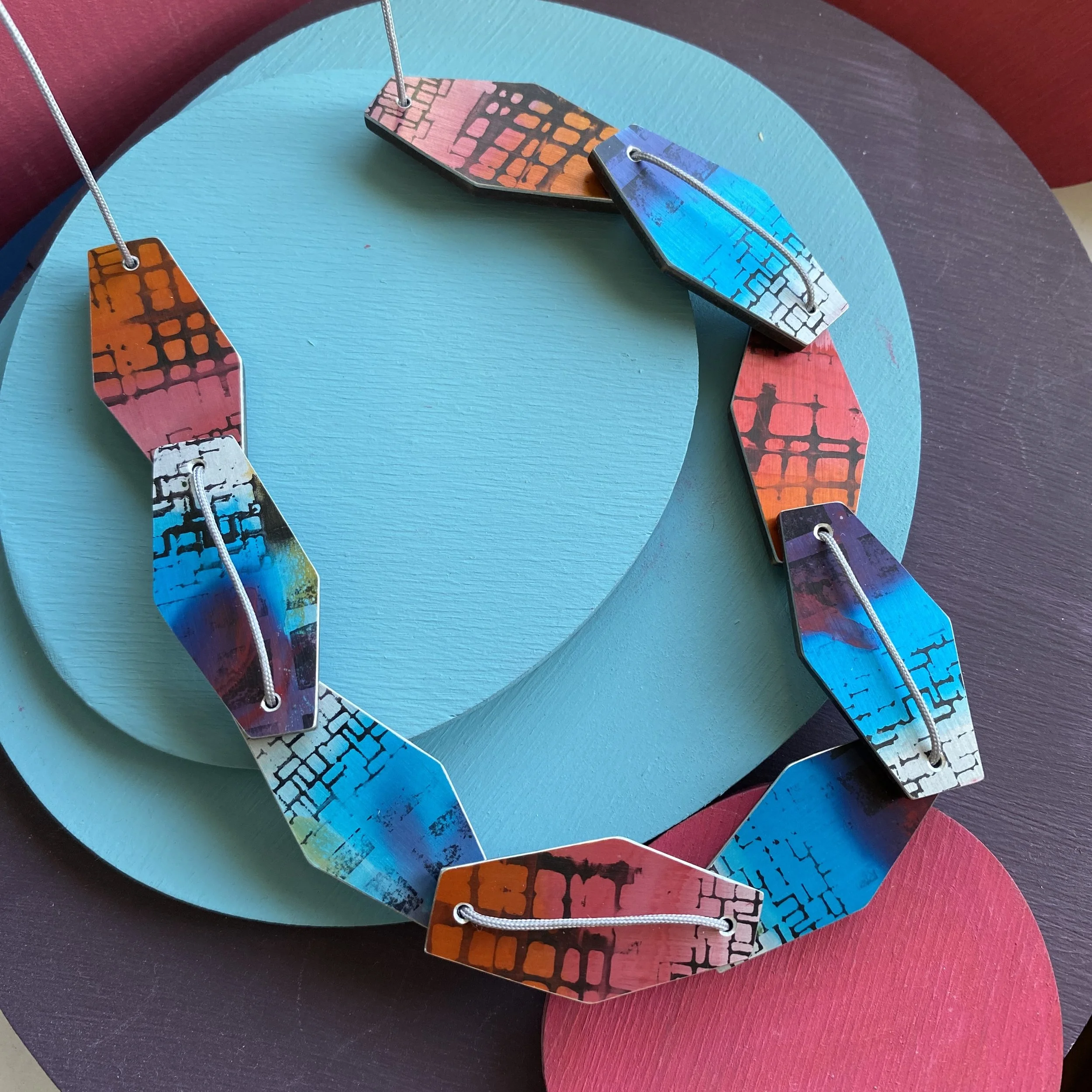 Blue/pink hexagonal 9 piece aluminium & walnut necklace.
