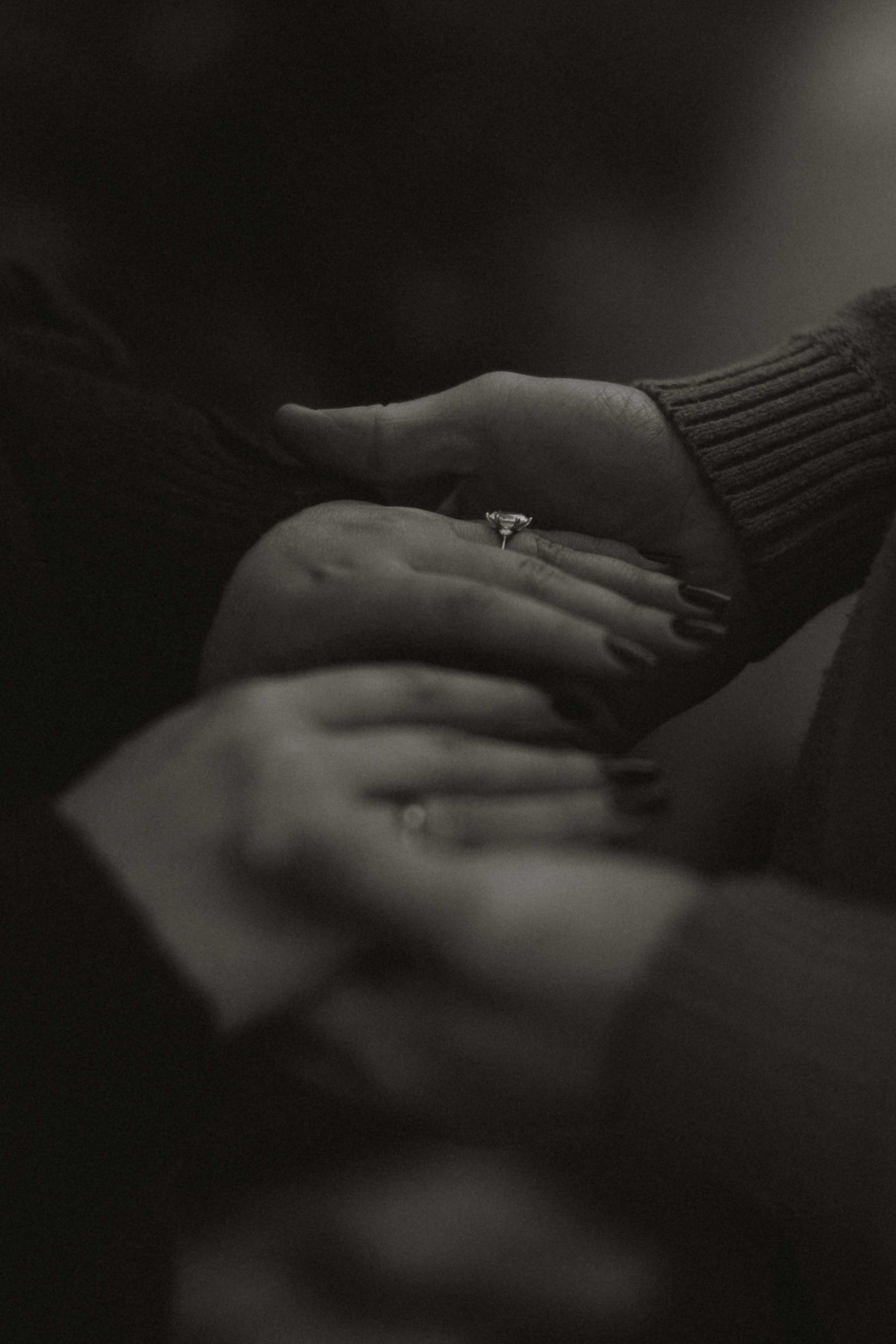 softly lit moment showing off ring details while couple hold hands outdoors in the beautiful lake district landscape