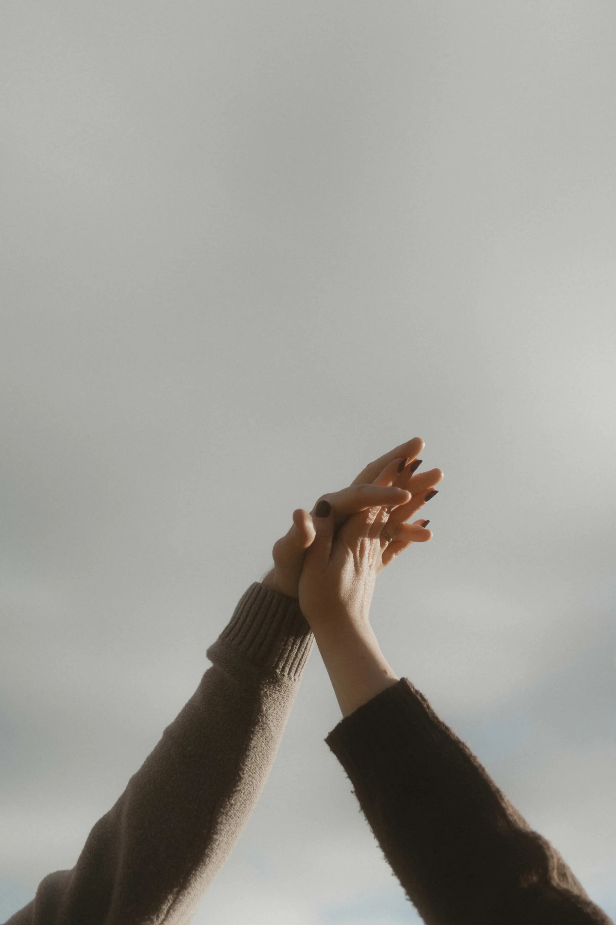 Relaxed Lake District wedding photography of a couple holding hands outdoors in soft lighting creative and artistic style