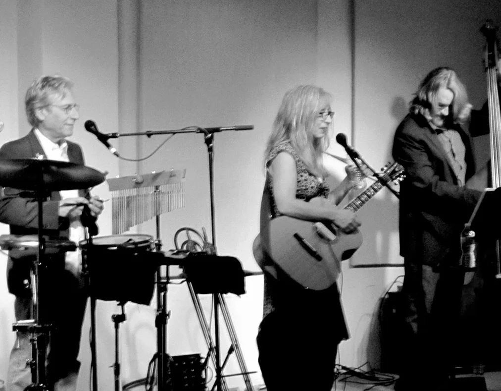two men and a woman musicians playing instruments