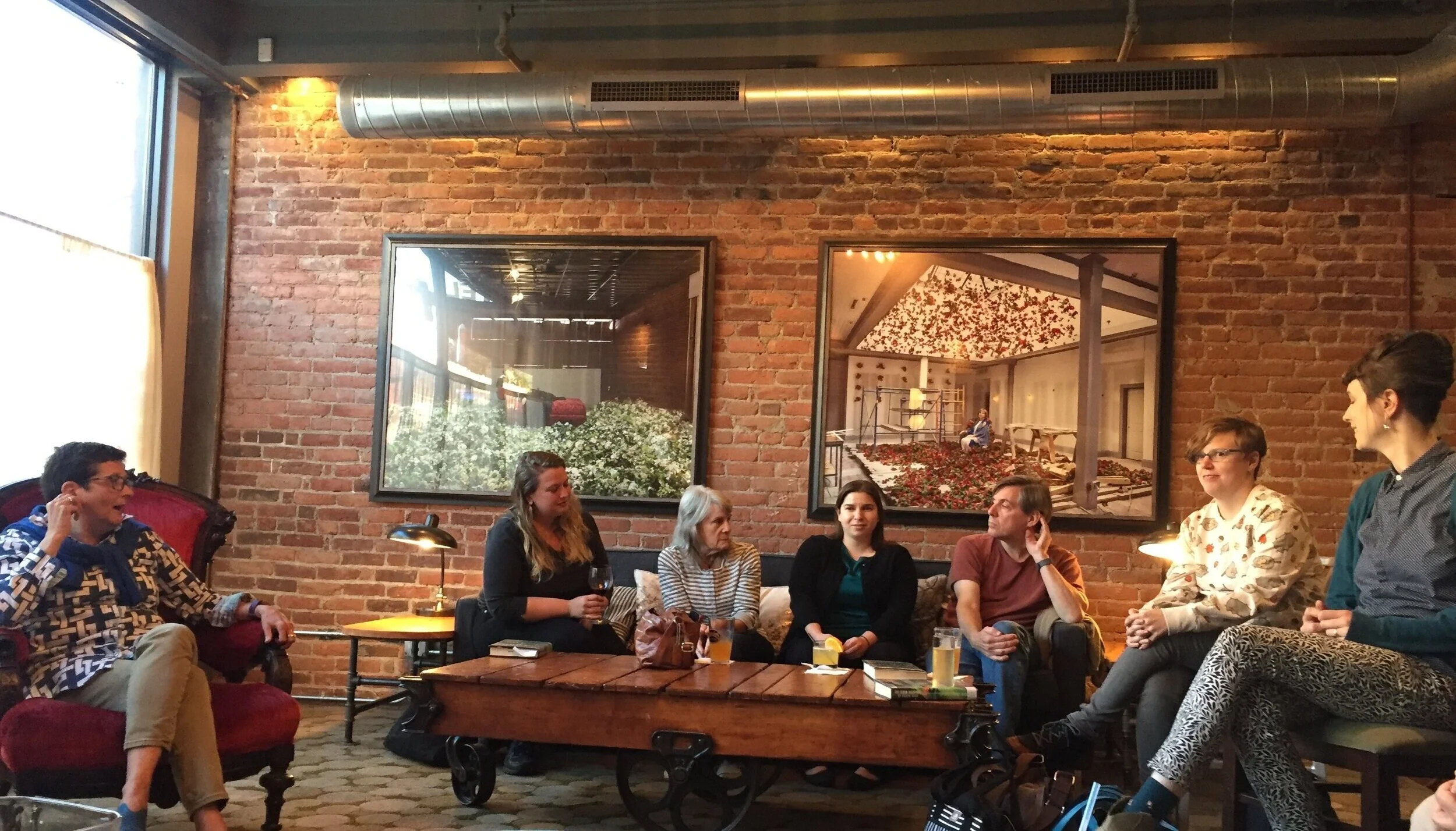 7 people sitting and discussing a book