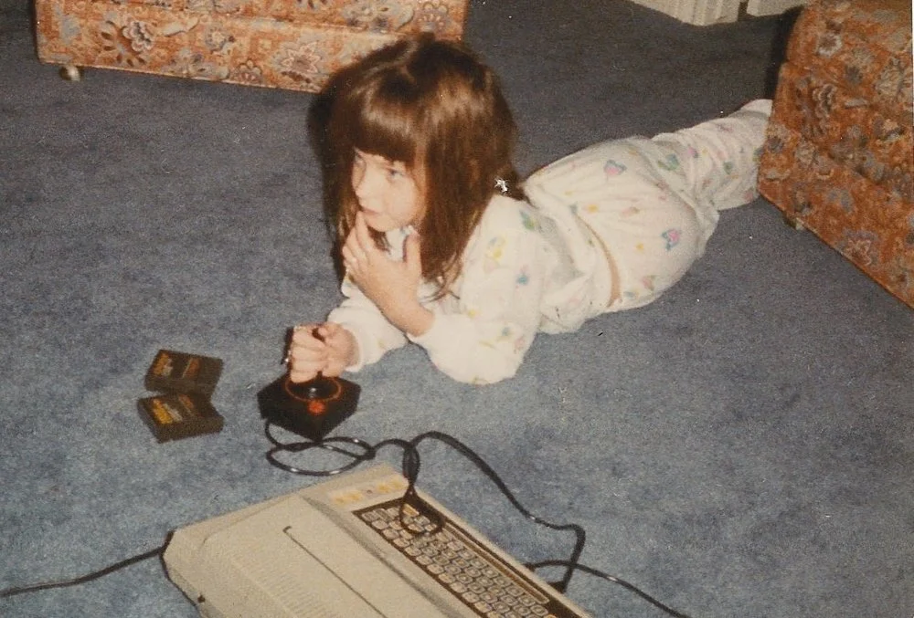 Me playing Pac-Man at about the same age and in about the same belly-flop position I would have read and written past lights-out. (No one caught a photo of that.) c. 1980