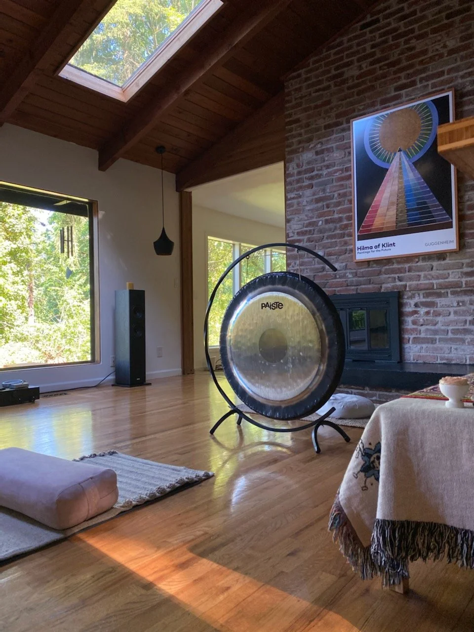 Large gong in a sunlit room set up for a sound bath and gong meditation