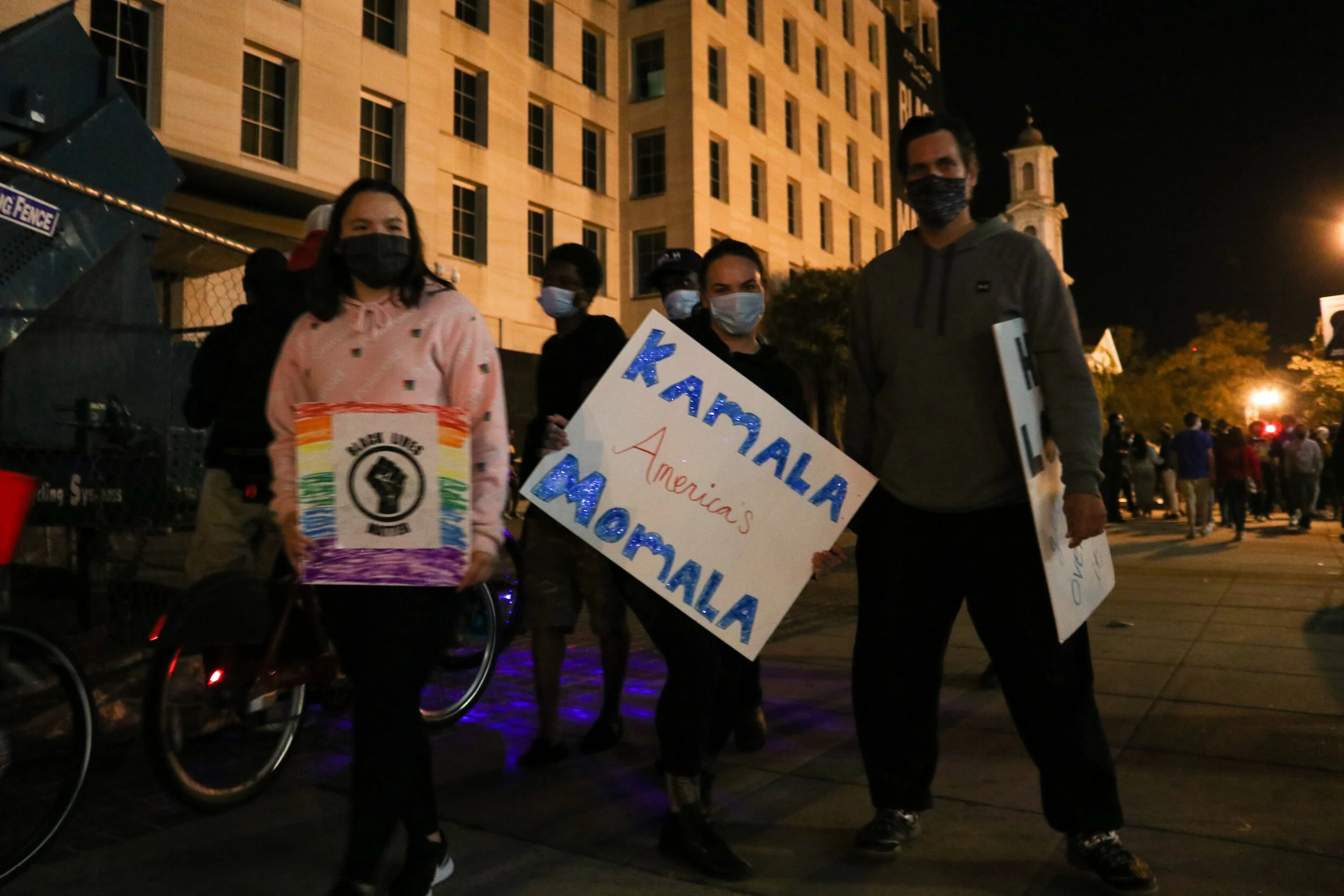 People walk through the plaza with signs supporting President-elect Biden and Vice President-elect Harris.