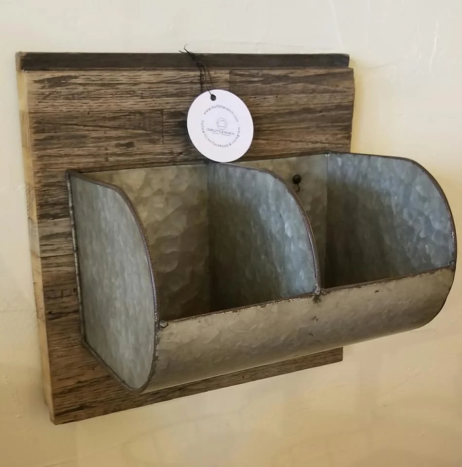 A set of old farm scoops mounted on a piece of reclaimed railcar flooring.