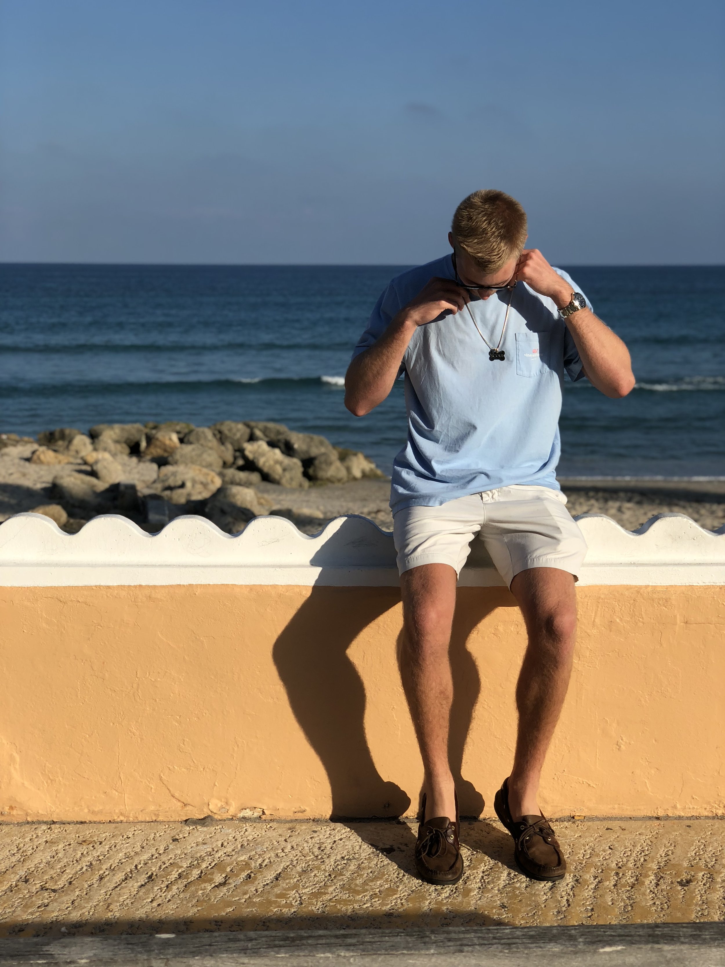 Adam sitting on a wall along the beach in West Palm Beach, Florida