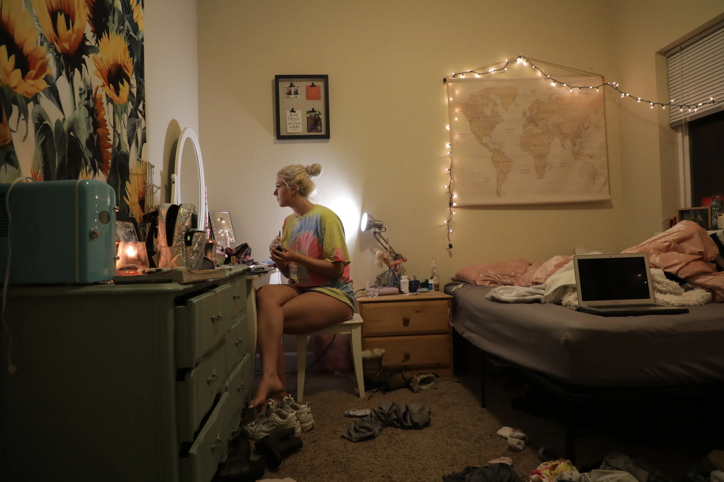  In a rare moment of solitude, Naomi looks at her reflection in the mirror in her bedroom in Eugene. Her room is filled with things that inspire her -- the world map, marked with pins of countries she plans to travel to, and a tapestry of sunflowers,