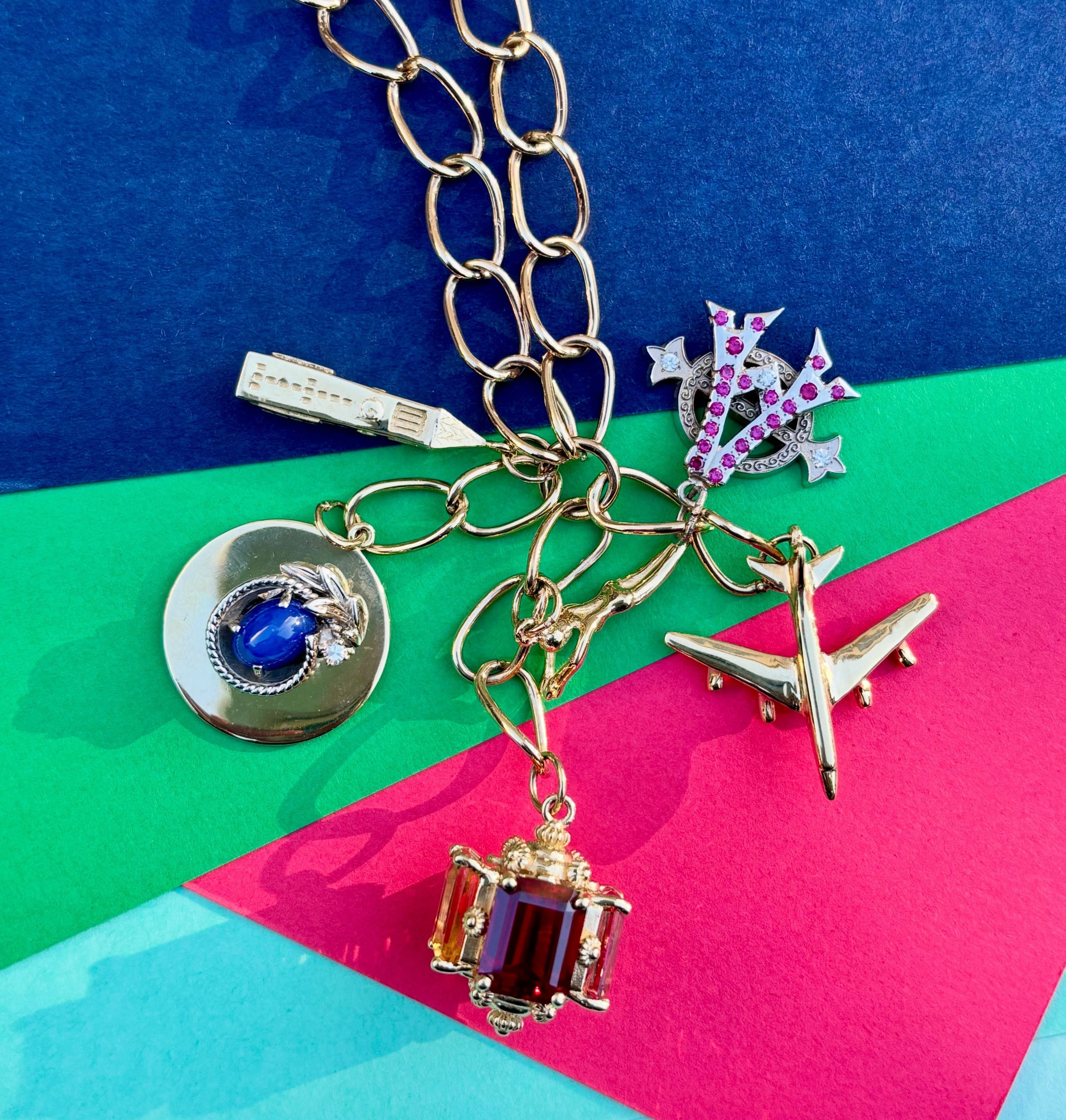 Love this mix of old and new! Clockwise from the top right: her sorority pin, airplane for love of travel, our 4-stone fob with family birthstones, a sapphire ring repurposed into a charm and our Cornell clocktower charm. ❤️ #tellyourstory