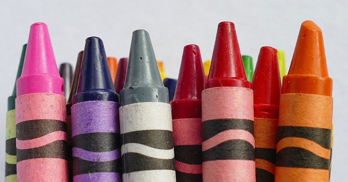 Close-up of colorful crayon sticks arranged with their tips pointing upward.