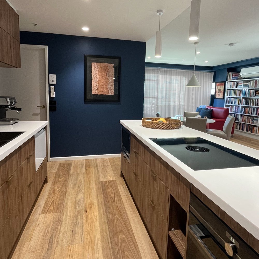 Kitchen design with simple timber and white cabinets and a blue painted wall designed by Hue and Space Interior Design