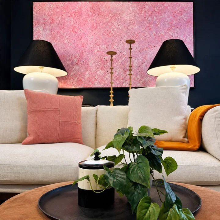 The console behind the sofa has two large table lamps and clay candle sticks