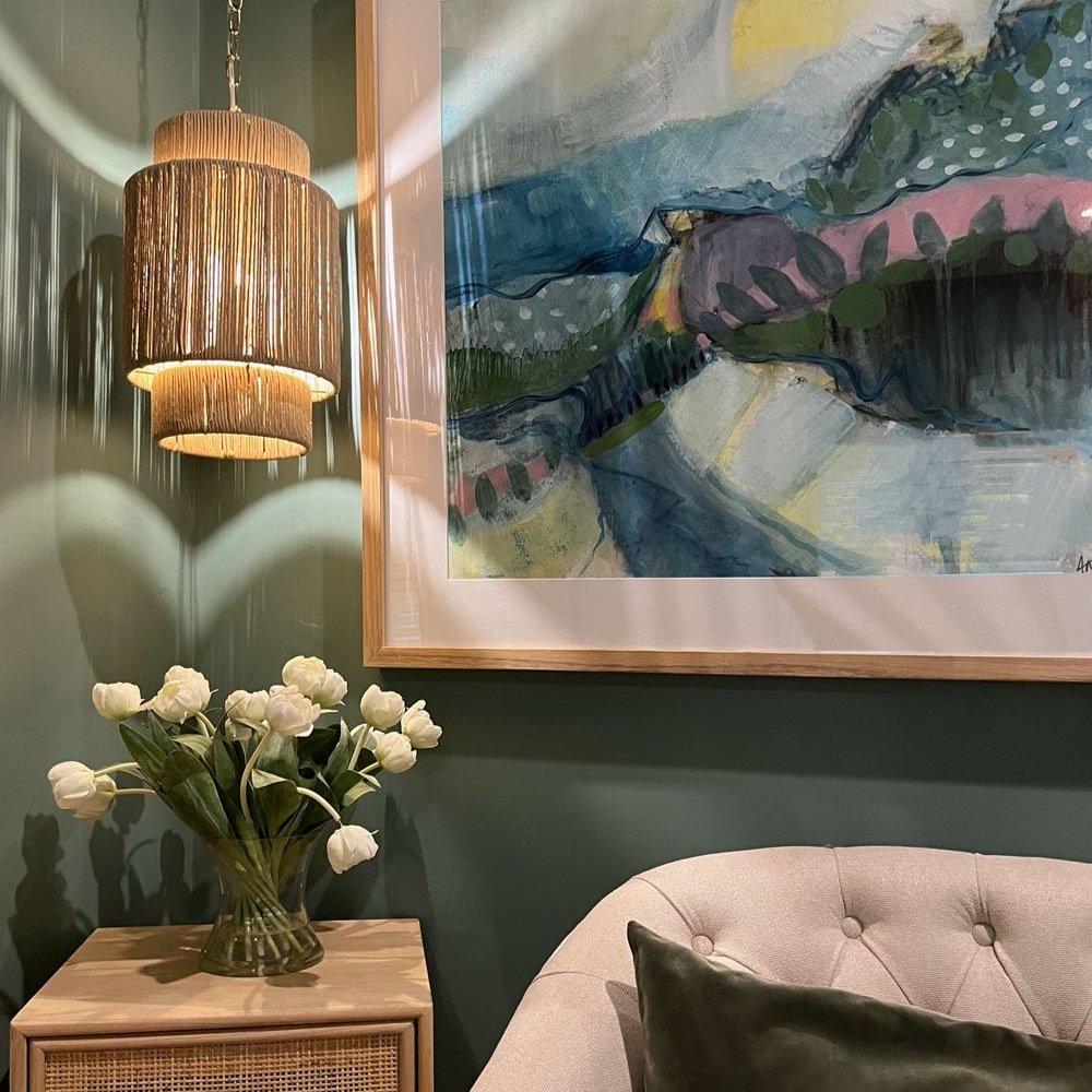 Rattan pendant light, sage green walls and flowers under colourful art in teenage girls bedroom designed by Hue and Space Interior Design