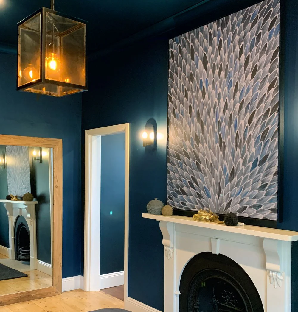 Deep colour done right. 

Our client's rich navy room shows how dark paint can create mood and sophistication when paired with these stunning elements: oversized artwork, warm lighting, and crisp white architectural detailing.

The lantern pendant an